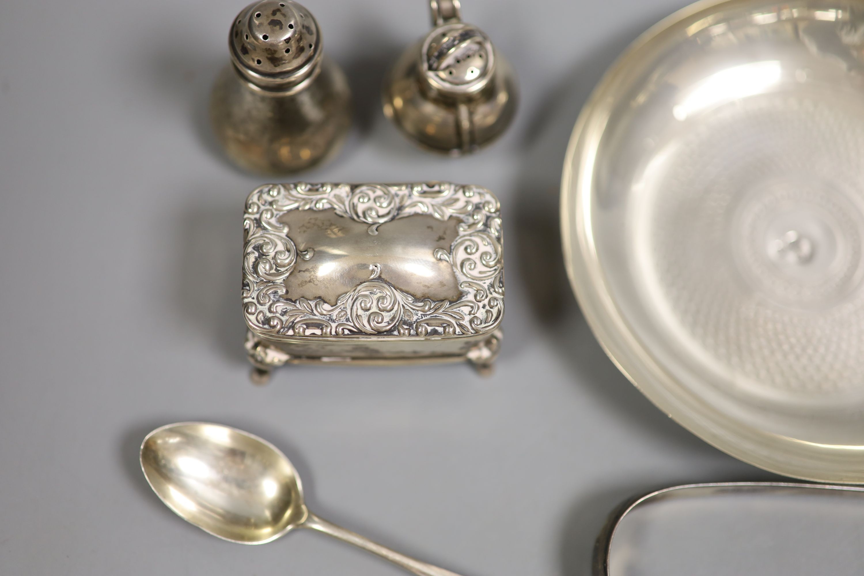 A Persian white metal tea cup and saucer and small sile items including two pepperettes, a trinket box and assorted minor flatware